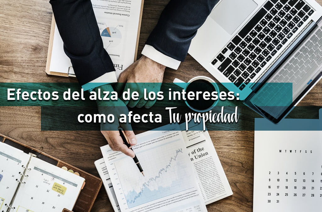 Persona de negocios revisando documentos financieros y laptop sobre efectos del alza de intereses en propiedades de Miami
