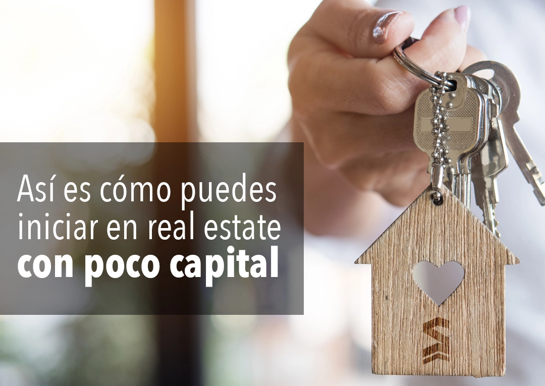 Mano sosteniendo llaves de casa con llavero en forma de corazon - como iniciar en real estate con poco capital