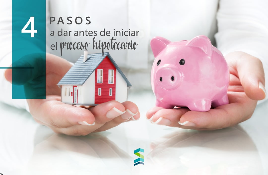 Manos sosteniendo modelo de casa y alcancia rosa representando pasos antes de iniciar proceso hipotecario en Miami