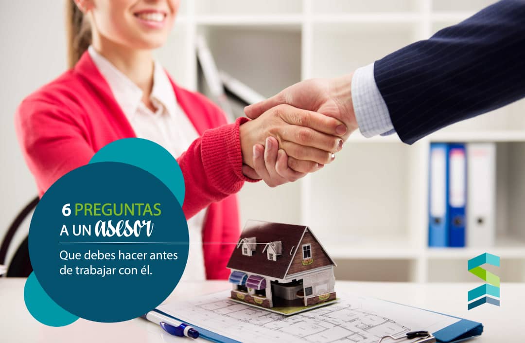 Apretón de manos entre asesor inmobiliario y cliente con modelo de casa en mesa de oficina en Miami