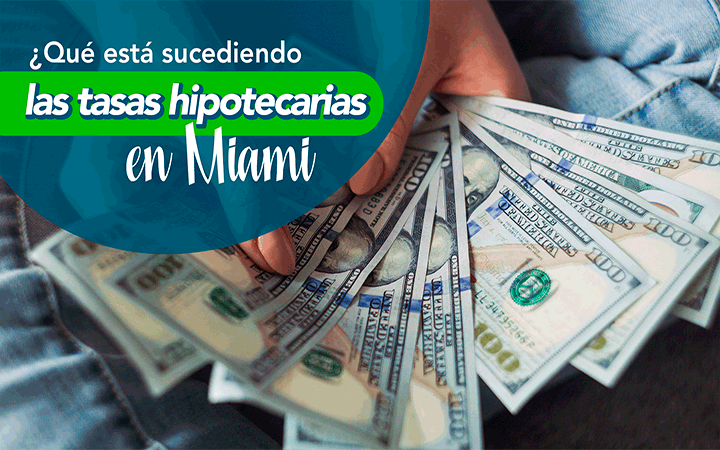 Manos sosteniendo billetes de dolares - que esta sucediendo con las tasas hipotecarias en Miami